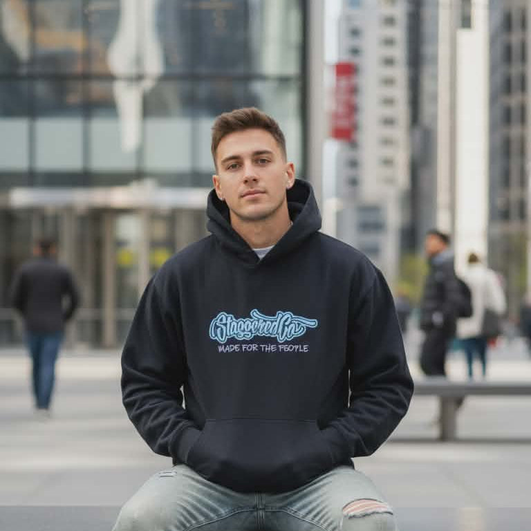 Person wearing a black hoodie with text, sitting on a bench in an urban setting.